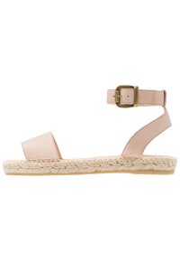 Ljusrosa lädersandal med ett brett tåband, ankelspänne och flätad jutesula; platt design.