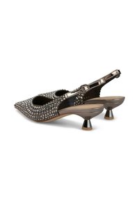 Zapatos slingback de punta afilada con textura negra tachonada, acentos metálicos y un exclusivo tacón cónico. Cuenta con un broche ajustable para un mejor ajuste.