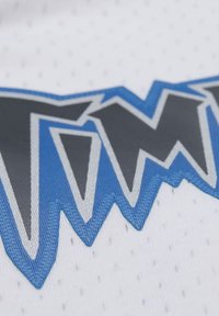 Weißer Stoff mit Netzstruktur zeigt ein auffälliges grafisches Design in Blau und Grau, das markant kantige Formen und Konturen präsentiert.