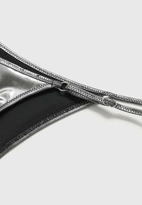 Black bikini bottom featuring a glossy silver accent and a zipper detail, with smooth fabric and exposed seams for added texture.