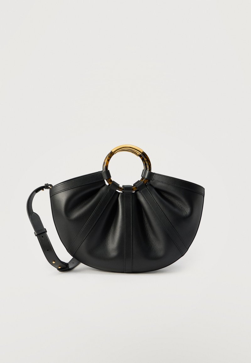 Μαύρη δερμάτινη τσάντα με φαρδύ, πιετέ σώμα, κυκλικές λαβές σε σχέδιο χελώνας και ρυθμιζόμενο λουρί ώμου σε ουδέτερο φόντο.