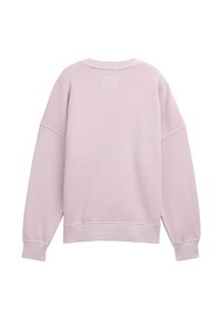Sudadera suave de color rosa con corte holgado, escote redondo, hombros caídos y puños acanalados. Presenta un pequeño parche cuadrado en la parte posterior.