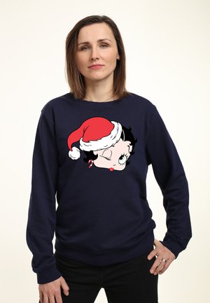 Marine sweatshirt med grafisk motiv af en tegneserie-kvinde iført en julesok, fremhævet med sort hår og en julebolle. Fremstillet af bomuldsstof med afslappet pasform.