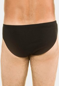 Mustat uimapuvun alushousut, jotka on valmistettu pehmeästä kankaasta. Niissä on tiukka istuvuus, sileä elastinen vyötärö ja minimaalinen peitto takana.