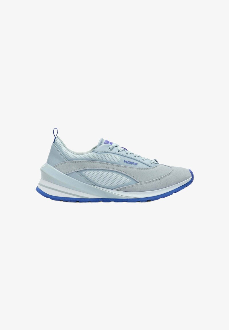 Chaussure de sport bleu clair en mesh et suède, design courbé, semelle intermédiaire blanche avec accents bleus, et fermeture à lacets.