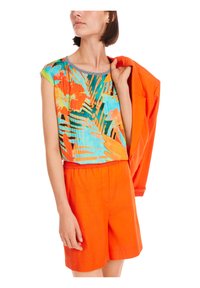 Buntes Kurzarmoberteil mit einem tropischen Druck in Orange, Blau und Grün, kombiniert mit orangen Shorts und einer passenden Jacke.