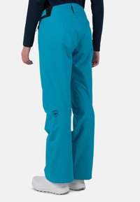 Turquoise sneeuwbroeken met een hoge taille, een zijriem en een logo-opdruk op de linker bovenbeen, met een losse, rechte pasvorm en een gladde textuur.