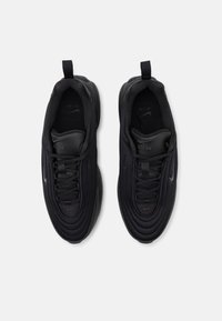 Black athletic shoes with a textured fabric upper, round toe, and lace closure. Features a pull tab on the heel and logo accents.