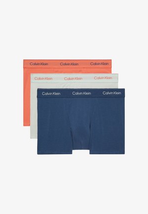 Drei Paar Boxershorts: marineblau, hellgrau und koralle. Jedes Paar hat einen weichen Stoff und einen elastischen Bund mit dem "Calvin Klein"-Logo.