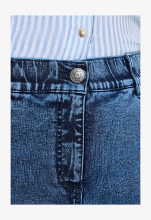 Jeans mit einer dunkelblauen Waschung, die einen silbernen Knopf, kontrastierende Nähte und eine strukturierte Oberfläche aufweist. Sichtbare Seitentasche auf der linken Seite.