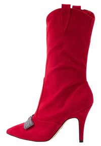 Botte de cheville en suede rouge avec un bout pointu, un talon aiguille et un accent décoratif en nœud à carreaux gris sur le côté. Texture lisse.
