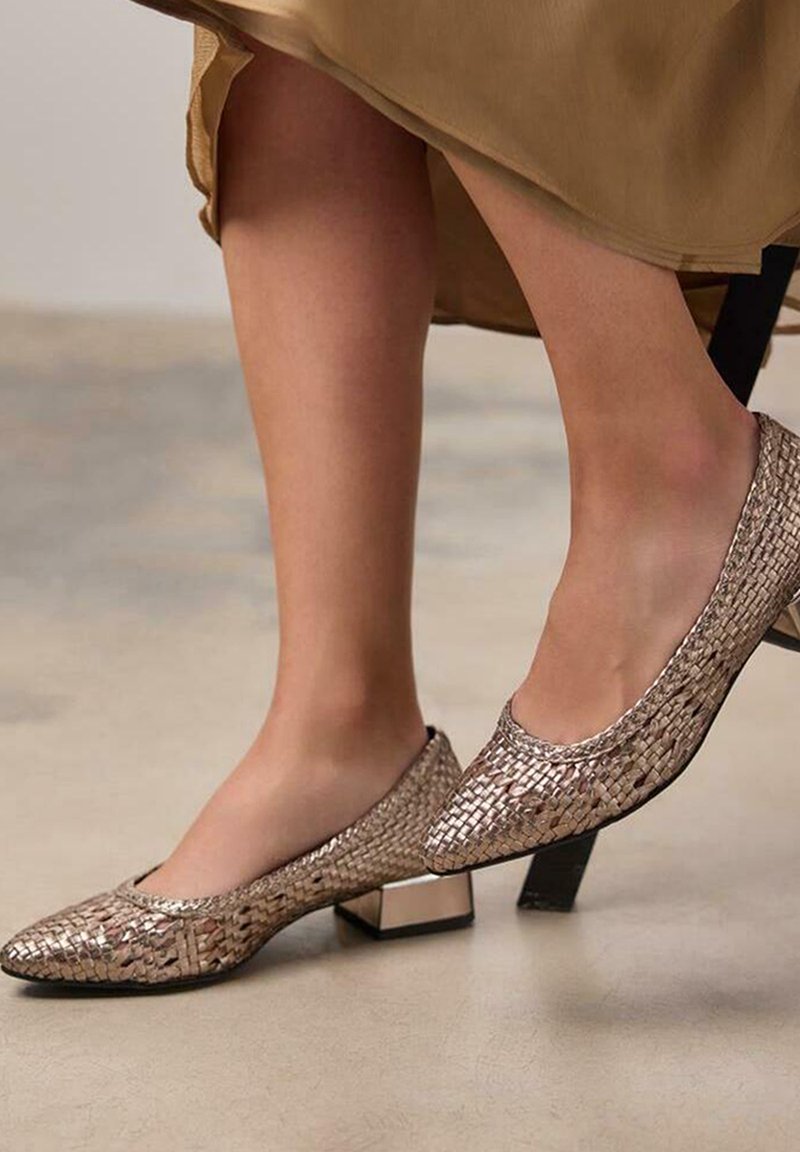Mocassins argentés métalliques avec une texture tissée et des talons carrés, présentant un bord lisse et un design à bout pointu.