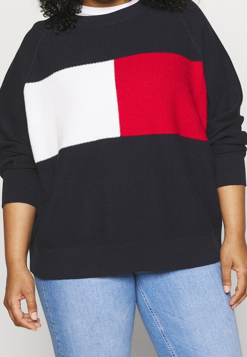 Strickpullover in Marineblau mit einem horizontalen Blockdesign in Weiß und Rot. Strukturstoff mit gerippten Bündchen und Saum.