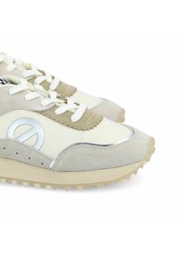 Chaussures de sport avec un schéma de couleurs blanc crémeux et gris, en matériaux en daim et synthétiques lisses, dotées d'un système de laçage et d'une semelle texturée.