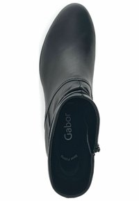 Černá kožená kotníková bota s kulatou špičkou, bočním zipem a minimálním švem. Vnitřek obsahuje logo "Gabor" na stélce.