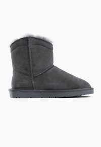Bota de tobillo de ante gris con un suave forro de piel de crema, puntera redonda y suela de goma negra. Los detalles de costura en los laterales añaden textura.