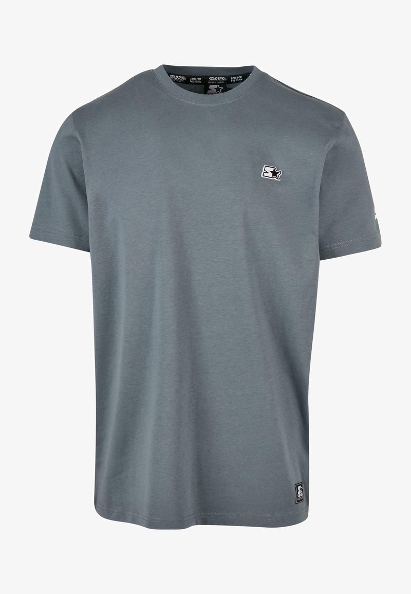 Szara koszulka krótki rękaw z bawełny, z okrągłym dekoltem, małym logo na piersi i metką przy końcu.