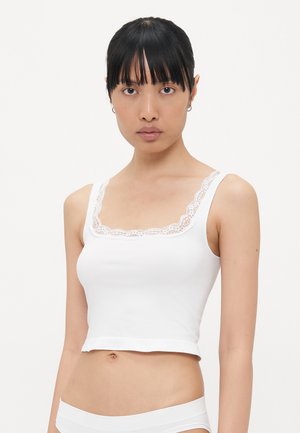Witte cropped tanktop met een vierkante halslijn versierd met een delicate kantafwerking. Soepele stof met een getailleerd ontwerp.