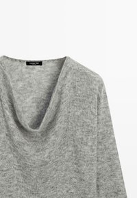 Szary sweter z kapturem typu komin, wykonany z miękkiego materiału o fakturowanym wykończeniu. Etykieta widoczna przy dekolcie, bez widocznych elementów metalowych.