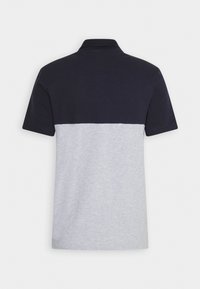 Polo skjorte med korte ærmer, der har en marineblå øverste del og en lysegrå nederste del. Lavet af blødt stof med krave.