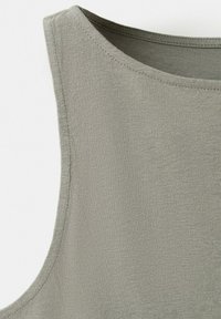 Close-up of light gray sleeveless knit top showing round neckline and fine stitching details.