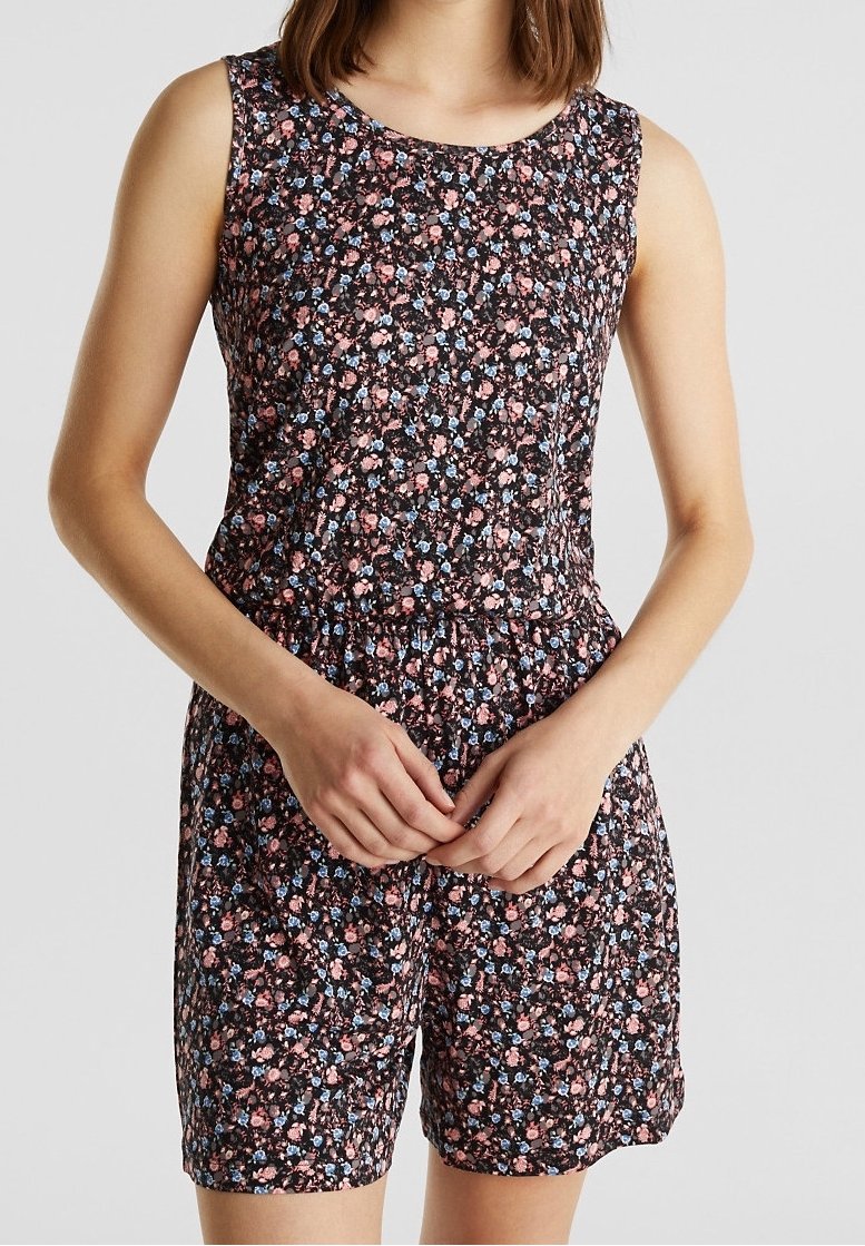 Combinaison sans manches à motifs floraux noirs, ornée de petites fleurs bleues et roses, taille élastique et shorts. Tissu doux et léger.