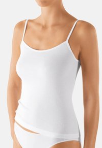 White cotton camisole with thin straps, a scoop neckline, and a fitted shape, featuring a smooth texture and minimal seams.