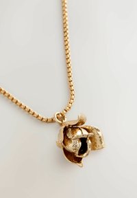 Goldfarbene Halskette mit einem rosenförmigen Anhänger, der detailreiche Blütenblätter und ein offenes Design aufweist, und die auf einer strukturierten Kette ruht.