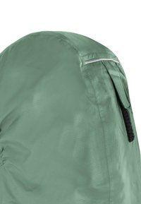 Hellgrüner Rucksack aus strukturiertem Nylon, mit geschwungener Form, waschbarer Handgriff und einem reflektierenden Streifen entlang des Reißverschlusses.