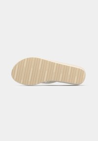Gummisåle med minimalistisk design, med en strukturert beige overflate og horisontale spor for grep.