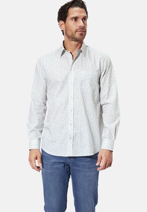 Light-colored button-up shirt with a subtle floral pattern. Long sleeves, standard collar, and soft fabric texture. Paired with blue jeans.
