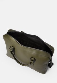 Bolso de cuero verde oliva con acabado texturizado, abertura de cremallera ancha, asas dobles y interior negro. Presenta acentos de hardware en tono plateado.
