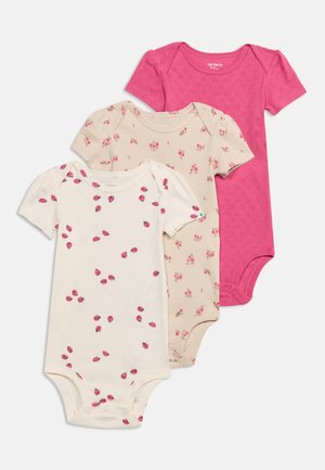 Three short-sleeve baby bodysuits in pink, beige with floral print, and white with ladybug print, laid out overlapping on a white background.
