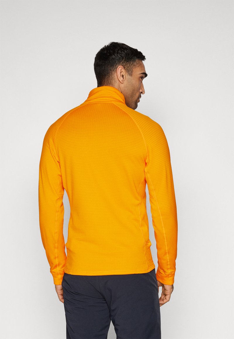 Oranje langemouwen pullover met een hoge kraag, voorzien van een textuurpatroon en een getailleerd ontwerp. Geen zichtbare logo's of accenten.