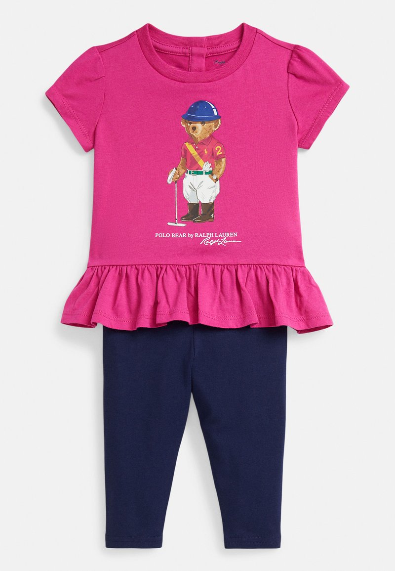 Vaikiškas komplektas su ryškiai rožine trumpomis palaidinukėmis su raukiniais, puoštas polo meškiuko piešiniu, derinamas su vientisomis tamsiai mėlynomis tamprėmis.