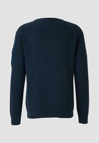 Navy blue ribbed sweater with long sleeves, round neckline, and a patch pocket on the left sleeve. Smooth texture and fitted shape.