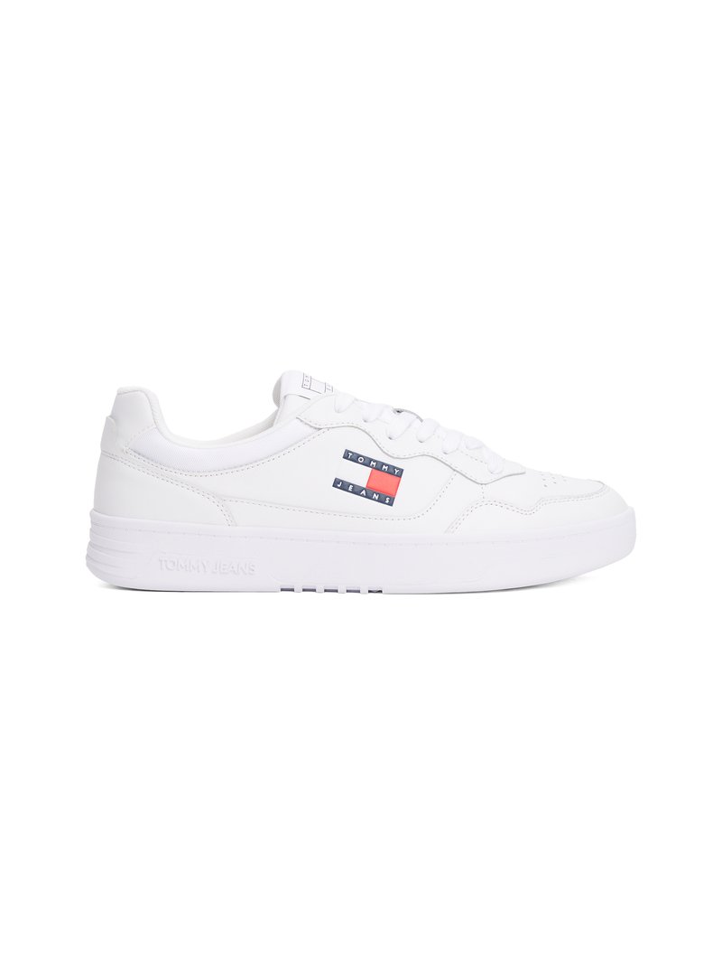 Sapalho branco com parte superior em couro liso, fecho de cadarços, colarinho almofadado e sola em borracha. Apresenta um logótipo "TOMMY JEANS" em vermelho e azul na lateral.