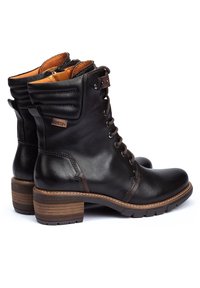 Svarta läderankelstövlar har en rund tå, snörningsdesign, vadderad krage och en brun trähäl med strukturerad gummisula för grepp.