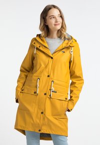 Gul vattentät regnjacka med huva, framfickor, dragsnoddar och svarta detaljer. Texturerad finish och knälängd design.