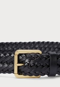 Crni pleteni kožnati remen s zlatnom metalnom kopčom. Tekstura je složena s pletenim dizajnom, ističući majstorsku izradu i izdržljivost.