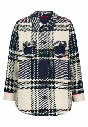 Chemise à boutons dans un grand motif à carreaux bleu marine et crème. Elle présente deux poches poitrine, un col, et un tissu texturé avec un ourlet arrondi.