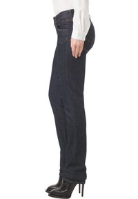 Ciemnoniebieskie dżinsy o slim fit, z klasycznym pięciopocketowym fasonem i subtelnymi detalami przeszyć; noszone z czarnymi botkami na obcasie.