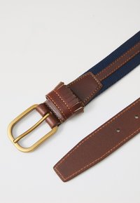 Brown leather belt with a navy woven fabric center, featuring a brass buckle and stitched detailing on both the leather and fabric.