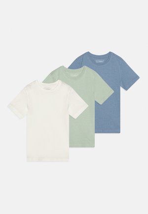 Trois t-shirts unis à manches courtes en blanc, vert clair et bleu, disposés en chevauchement décalé sur fond blanc.