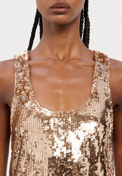 Top en rose gold recouvert de sequins, avec un encolure dégagée et des bretelles texturées, offrant une surface lisse qui reflète la lumière.