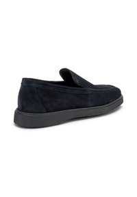 Scarpe slip-on in suede nero con punta stondatrice e suola piatta in gomma, caratterizzate da cuciture minime e una superficie liscia.