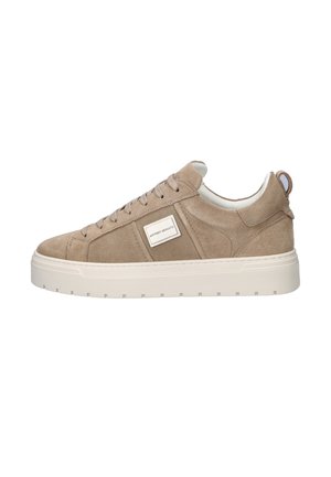 Beige suede low-top sneaker with lace-up front, thick white rubber sole, pull tab at heel, and a small rectangular brand label on the side.