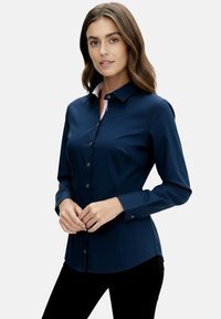 Navy blue button-up shirt with long sleeves, a pink inner collar, and a tailored fit. Smooth fabric with a subtle sheen.