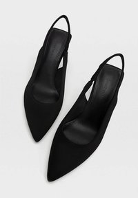 Svarta slingback-klackar med spetsig tå, slät tygöverdel och en diskret rem vid vristen. Mjuk inredning för komfort.