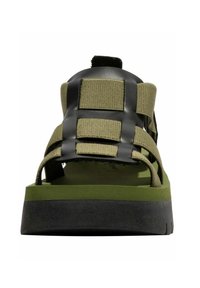 Zelené sandály s černými gumovými pásky, mají široké otevření pro prsty, texturovaný povrch a silnou černou podrážku.